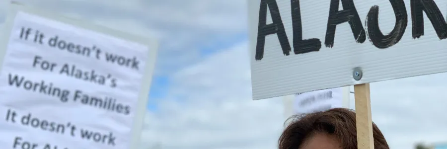 Three people holding rally signs